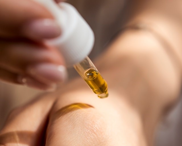 オイルを手の甲に付けている人の手の写真