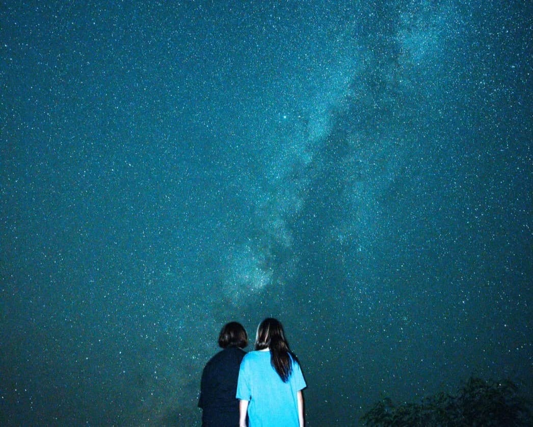 星空を眺める二人の女性の写真